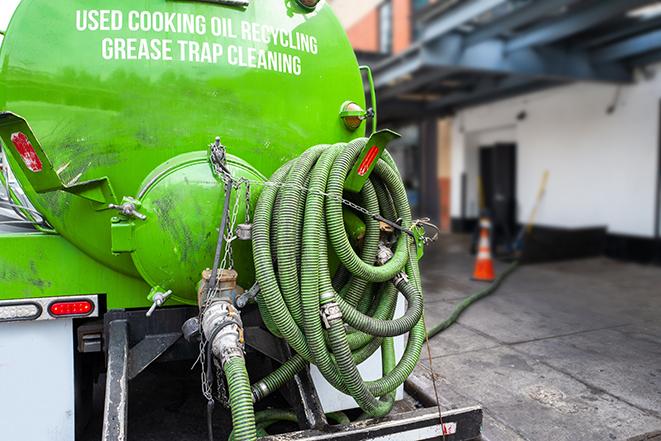 a technician pumping a grease trap in a commercial building in Medford NY